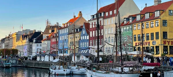 Farverige huse og sejlskibe langs kajen i Nyhavn i København